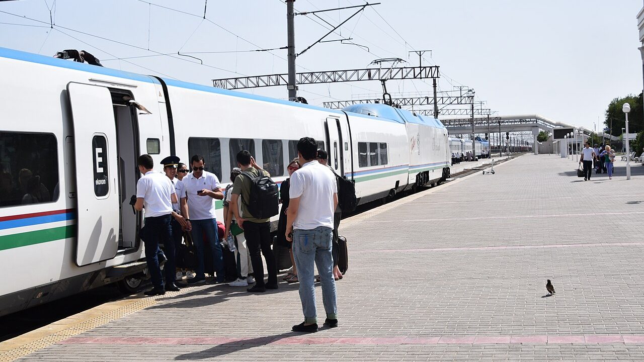 Passengers boarding an Afrosiyob train on the platform with luggage